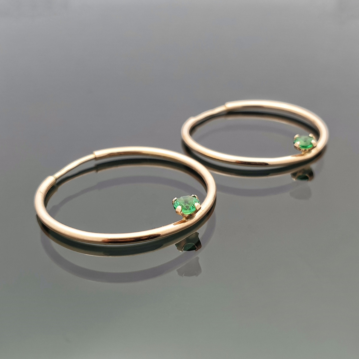  Round gold earrings decorated with green zircons (318)